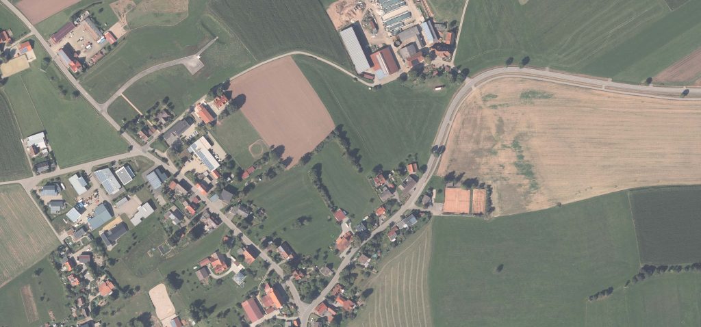 Luftaufnahme des Baugebiets 'Bildstockäcker' in Königsfeld im Schwarzwald. Zu sehen sind Felder, Gebäude und Straßen, die das Gebiet durchziehen, sowie angrenzende Wohnhäuser und landwirtschaftliche Flächen.